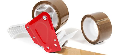 Brown parcel tape roll on tape gun.