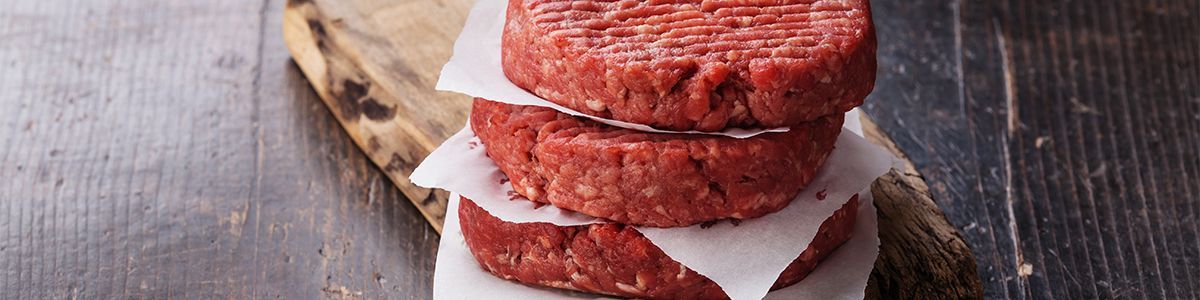 Stacked burgers separated by burger paper.