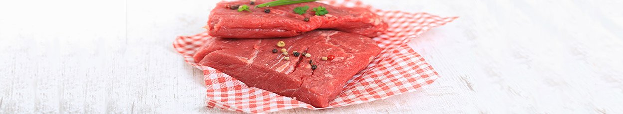 Meat displayed on two red gingham sheets.