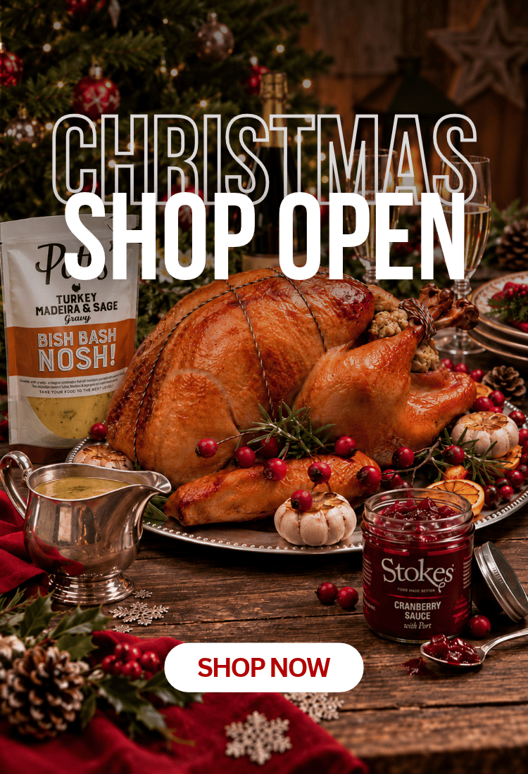 A festive holiday table scene with a roasted turkey on a platter, a bag of Rye Turkey Marinade & Sage Bish Bash Nosh!, a jar of Stokes Cranberry Sauce, and large overlaid text reading 'CHRISTMAS SHOP OPEN' with a 'SHOP NOW' button.